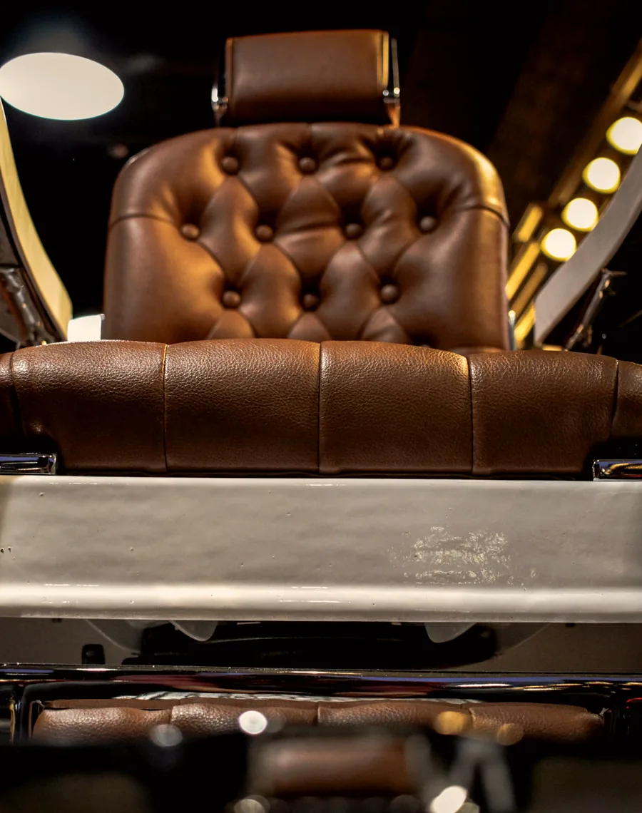 Fauteuil de barbier en cuir capitonné dans un salon de coiffure